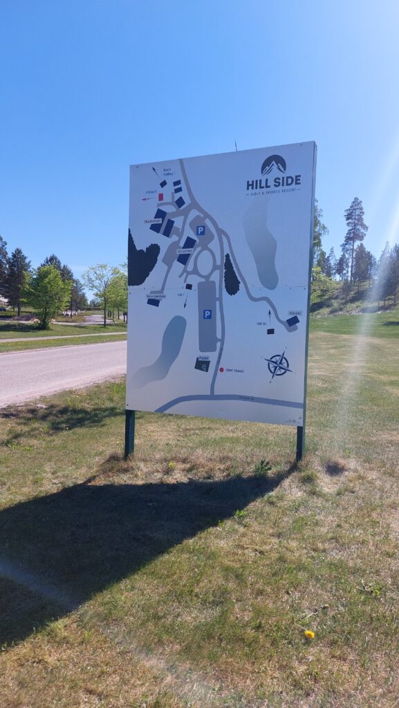 Hill Side -kentän aluekartta opastaulussa, pystytettynä tienvarteen nurmikolle